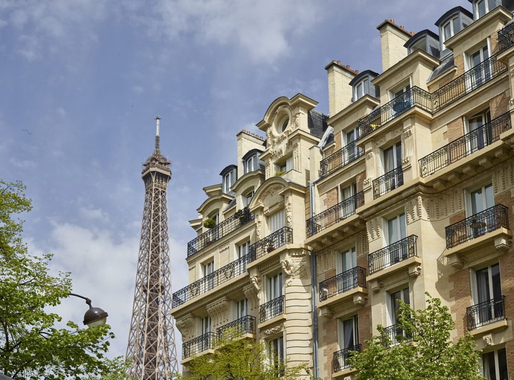 Vue globale d'un immeuble haussmanien avec des menuiseries extérieures sur mesure en bois blanches gamme prestige