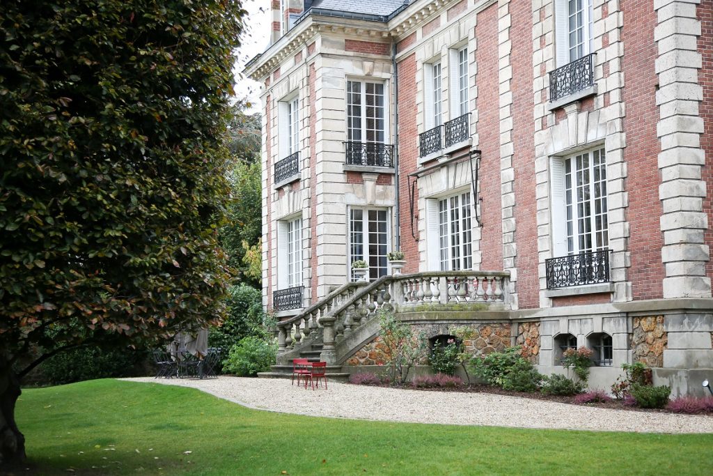 Vue extérieure d'un bâtiment ancien avec des menuiseries extérieures sur mesure en bois gamme tradition